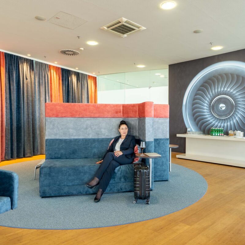 Graz Airport Lounge von innen mit Dame auf Bank